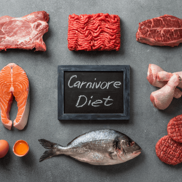 Various meats and fish around a chalk board with the word carnivore written on it
